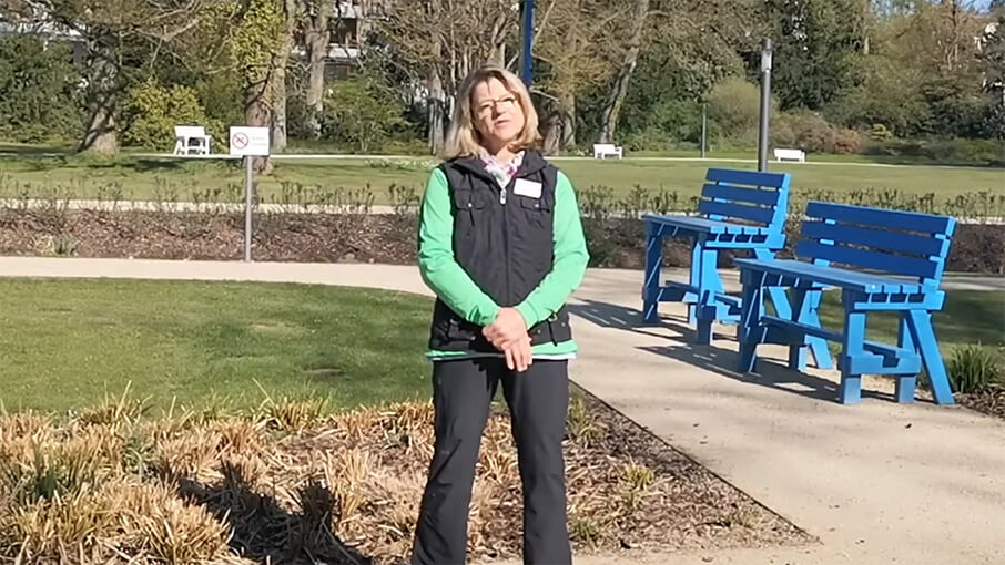 Frau im Park erklärt QiGong Übungen