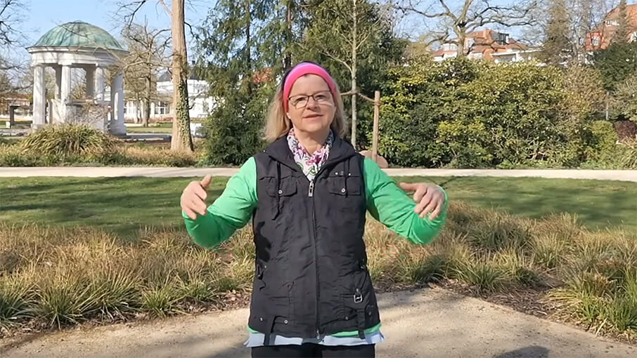 Frau macht QiGong Übung vor